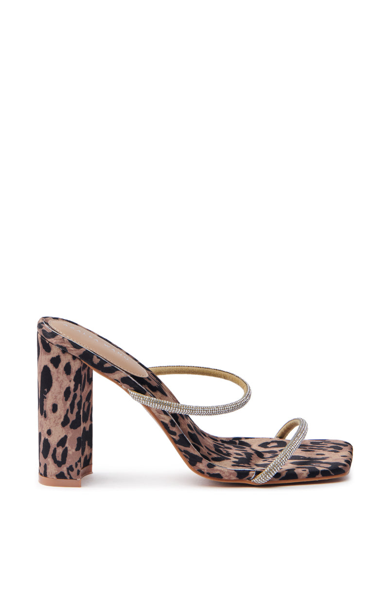 The AZALEA WANG EULALIA Leopard Slip-On Sandal boasts a high-heeled mule design with leopard print, featuring two thin rhinestone straps and a chunky block heel. This elegant sandal combines animal print with shimmering embellishments for a stylish and bold look.