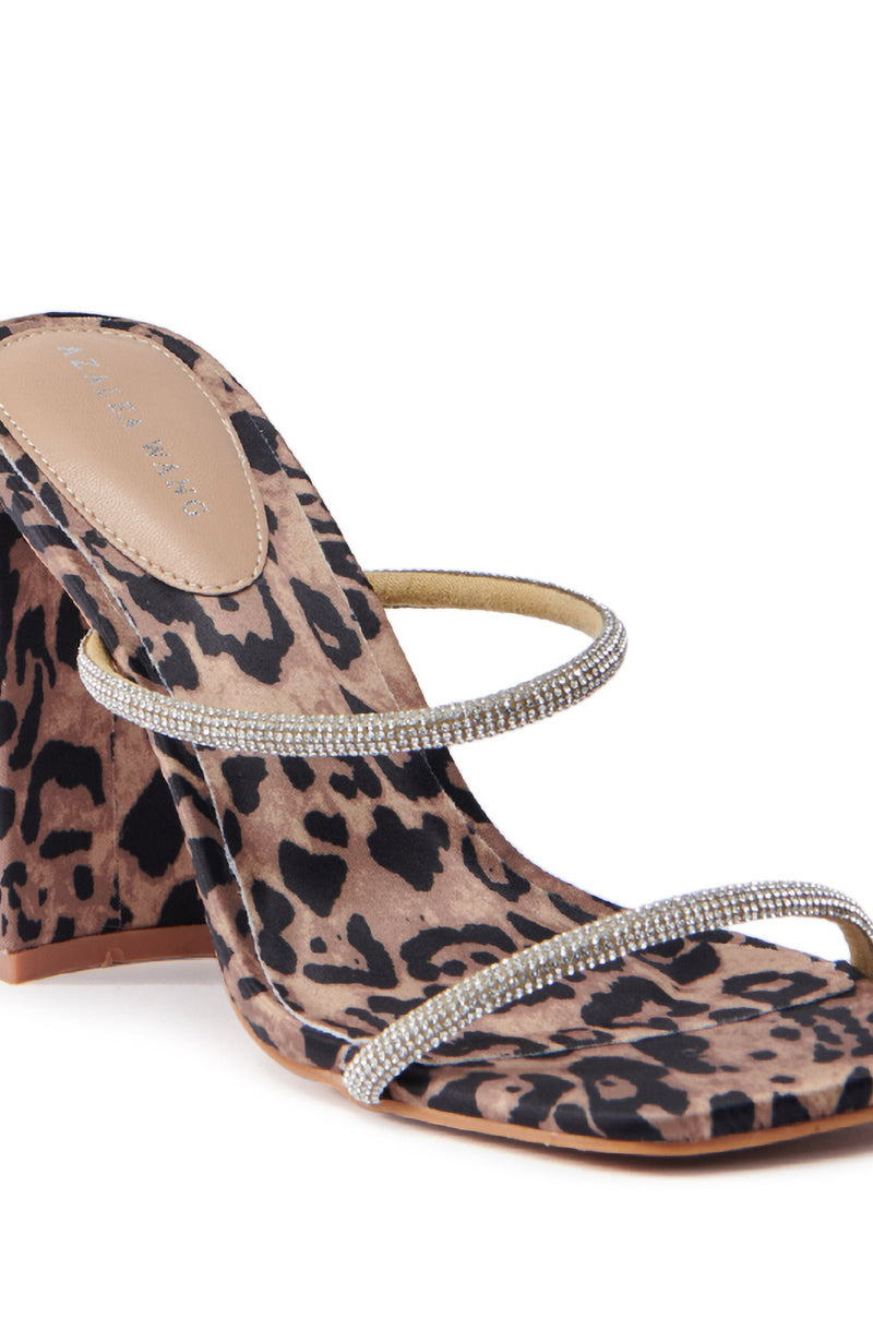 The AZALEA WANG EULALIA Leopard Slip-On Sandal features a chic leopard print, two rhinestone straps across the front, an open toe, and a chunky block heel for a glamorous touch to any outfit.