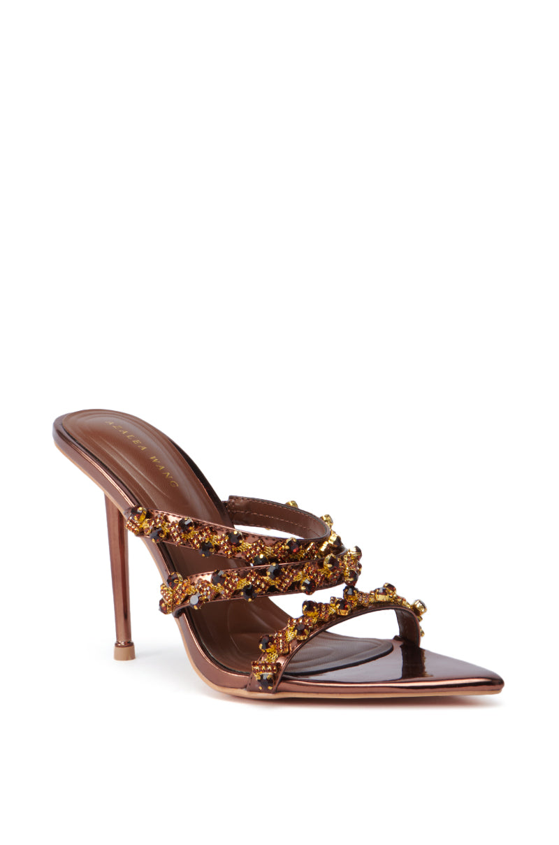 Enhance your elegance with the AZALEA WANG EUREKA BRONZE EMBELLISHED STILETTO SANDAL, featuring an open pointed toe and glossy brown faux leather upper. The high-heeled design showcases three crisscrossing straps embellished with amber-colored beads and a slim stiletto heel, making it a stylish choice.