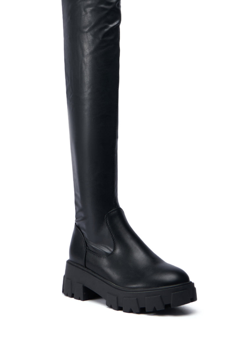 The AZALEA WANG EUREVA BLACK FLAT BOOT, featuring a chunky sole and a smooth faux leather texture, is showcased against a plain white background.