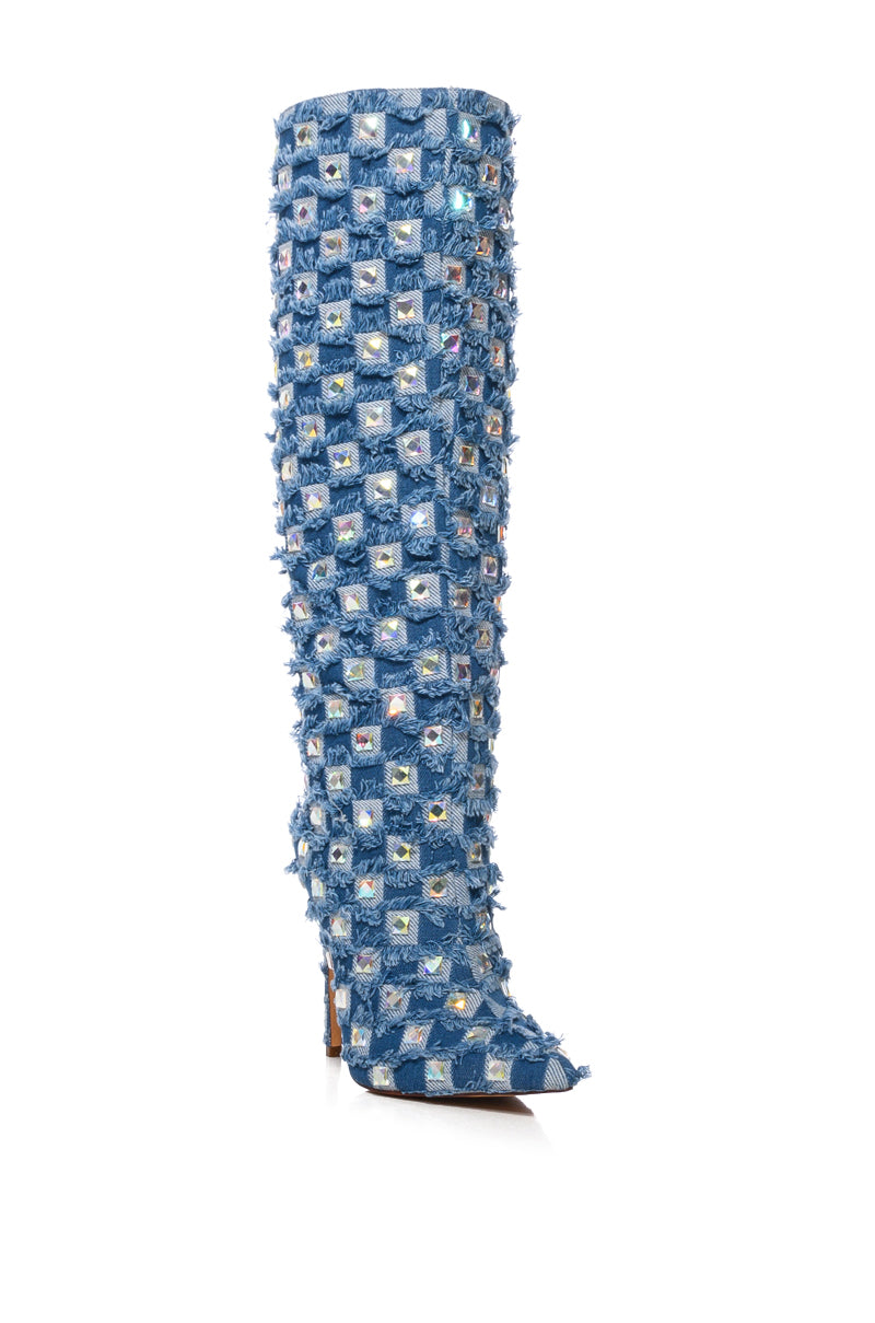 The AZALEA WANG EVE Denim Knee High Embellished Boot features a pointed toe, stiletto heel, and rhinestone accents in a patchwork of blue denim with colorful gems. It has a textured, fringed appearance. 6