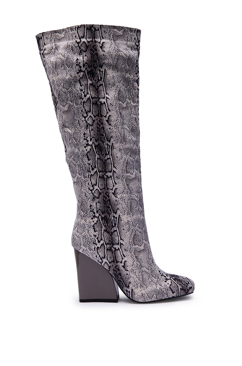 The AZALEA WANG EVERGREEN GREY SNAKE PRINT CHUNKY HEEL BOOT is a tall, knee-high boot with a gray and black snake print and an angled chunky heel, shown in side profile against a white background.