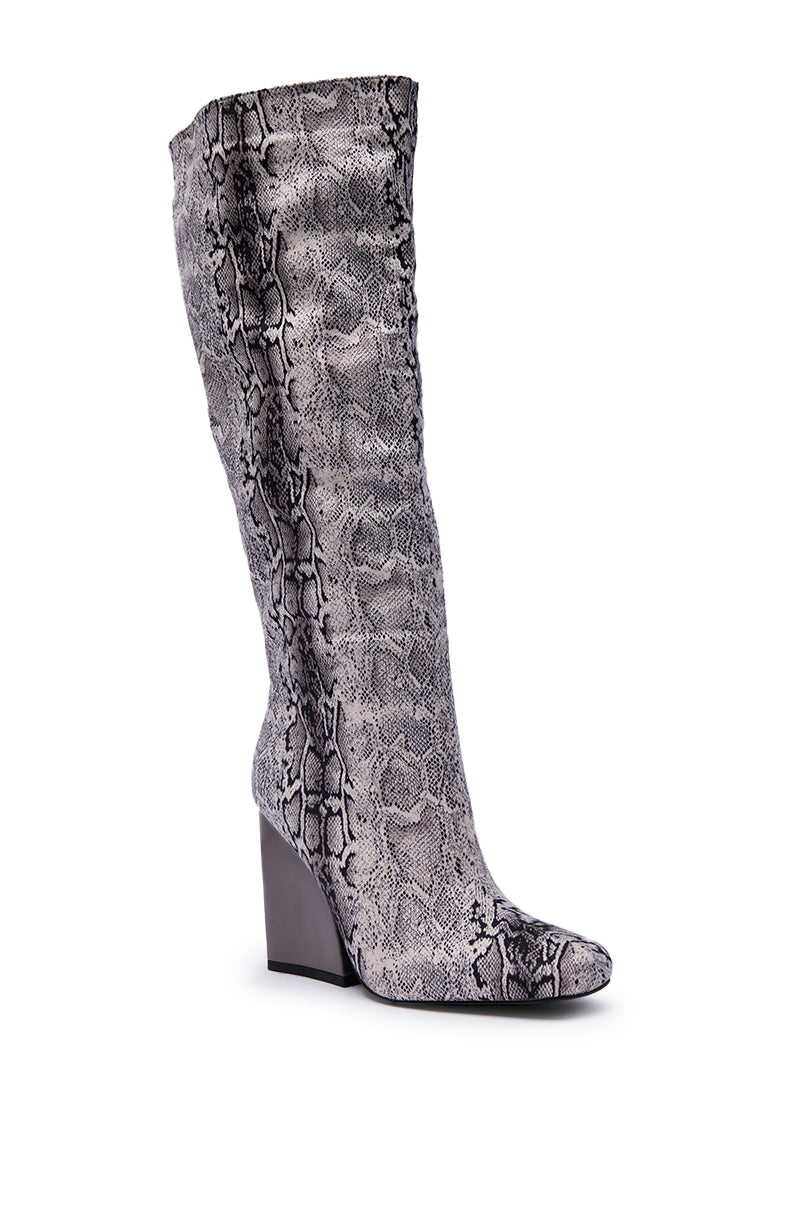 The AZALEA WANG EVERGREEN GREY SNAKE PRINT CHUNKY HEEL BOOT is a tall, knee-high boot with a gray and black snake print, high chunky heel, slightly pointed toe, and textured details for style.