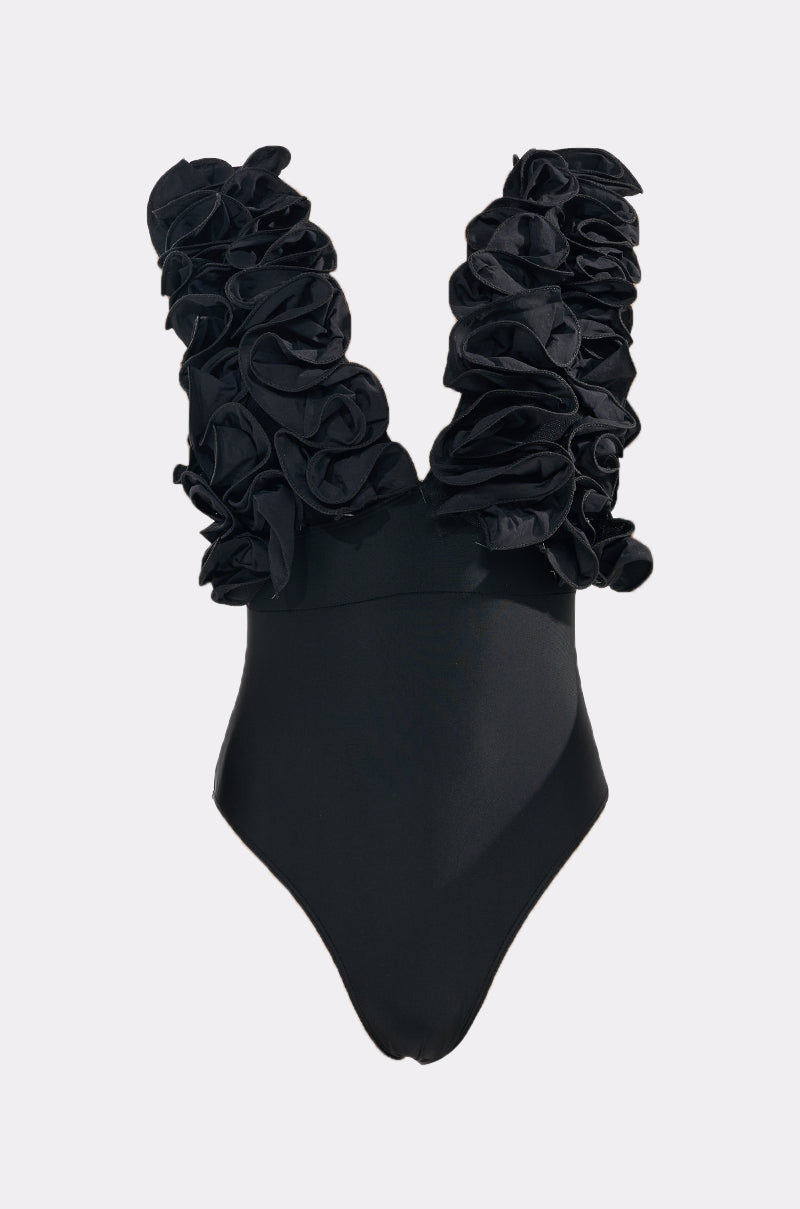 The FEEL MY POWER SWIMSUIT is a black one-piece with a deep V-neckline and large ruffle trim on the shoulder straps, shown against a light gray background. 4