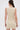 A woman with long dark hair in a low ponytail faces away, wearing the FEELIN SWEET Knit Sweater Dress with Pearls—a sleeveless, figure-hugging mini dress—against a plain light background.