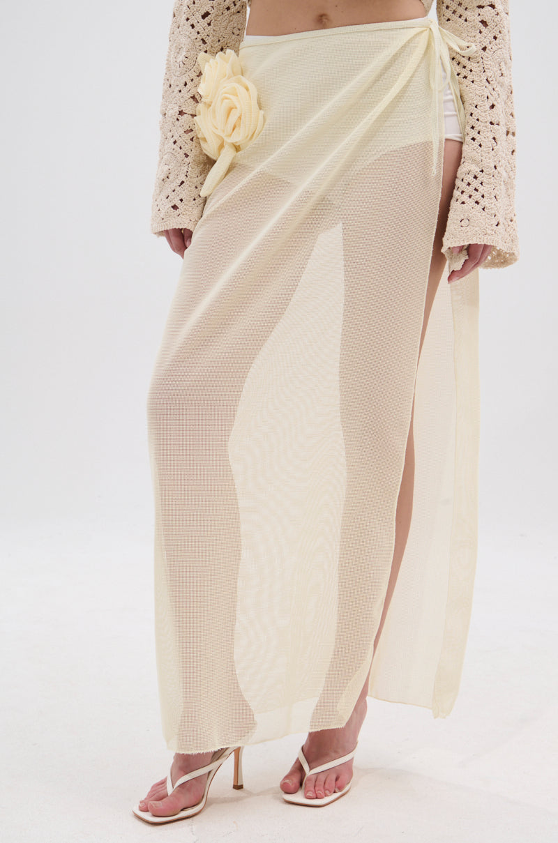 Wearing the CROCHET BEAUTY COVER UP SKIRT in sheer light yellow with a large fabric flower at the waist, white bottoms and heeled sandals, plus a beige crocheted long-sleeve top—this look is perfect for beach to brunch. 2