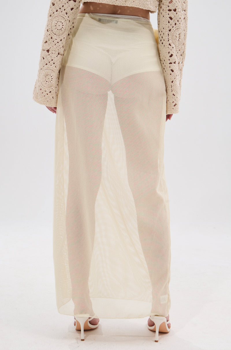 A person styles the CROCHET BEAUTY COVER UP SKIRT over high-waisted underwear and a cream crochet top, finished with white heeled sandals for a chic beach-to-brunch look against a light background. 4