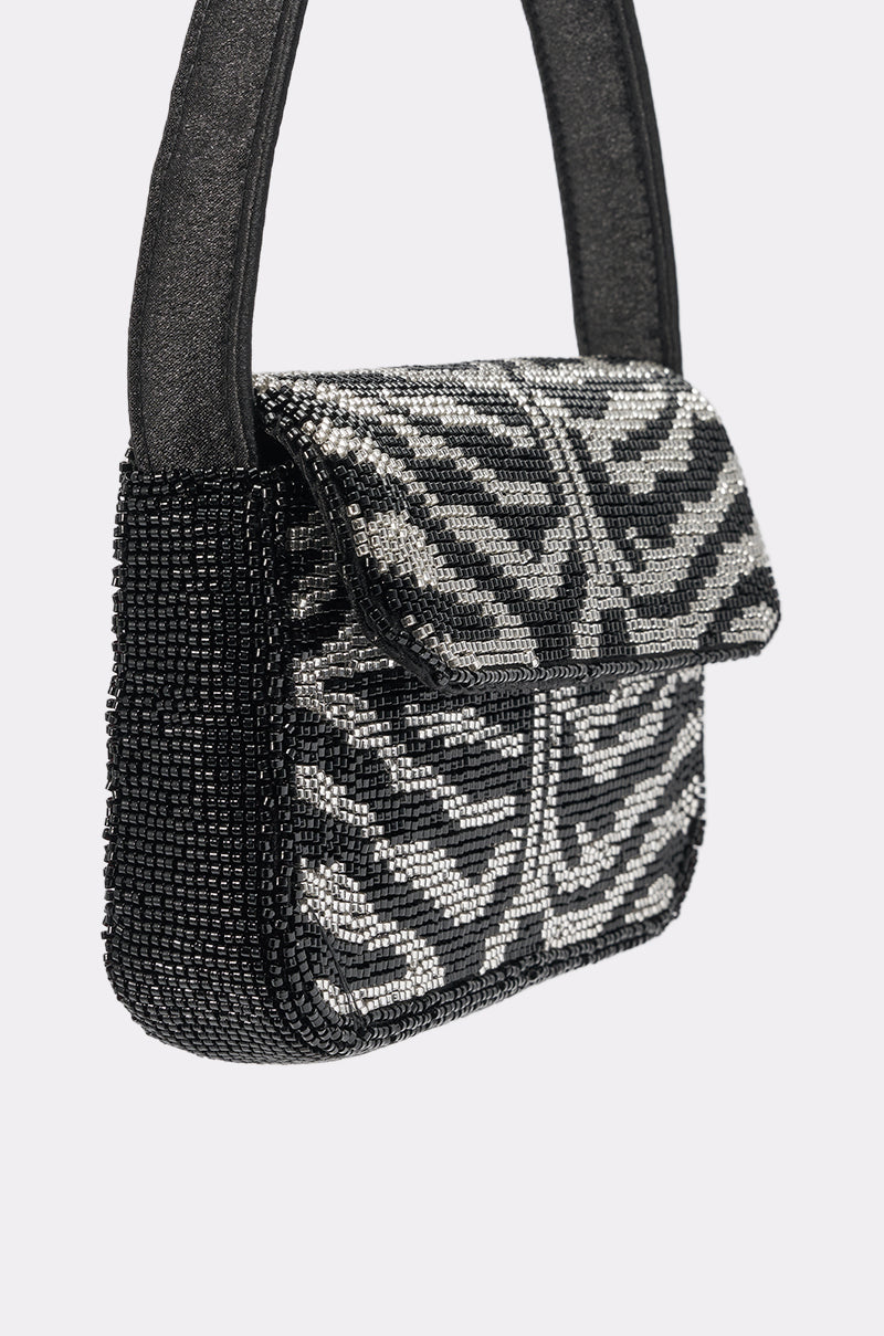 The VIVIANNE BEADED PURSE features black and silver zebra-striped beadwork, a flap closure, and a thick textured handle—a bold statement clutch for your next evening out. 5