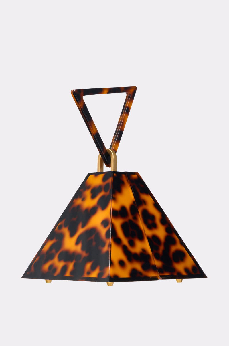 The TOP OF THE PYRAMID PURSE is a pyramid-shaped handbag with a tortoiseshell pattern, gold accents, and a triangular top handle, displayed against a plain light background. 0