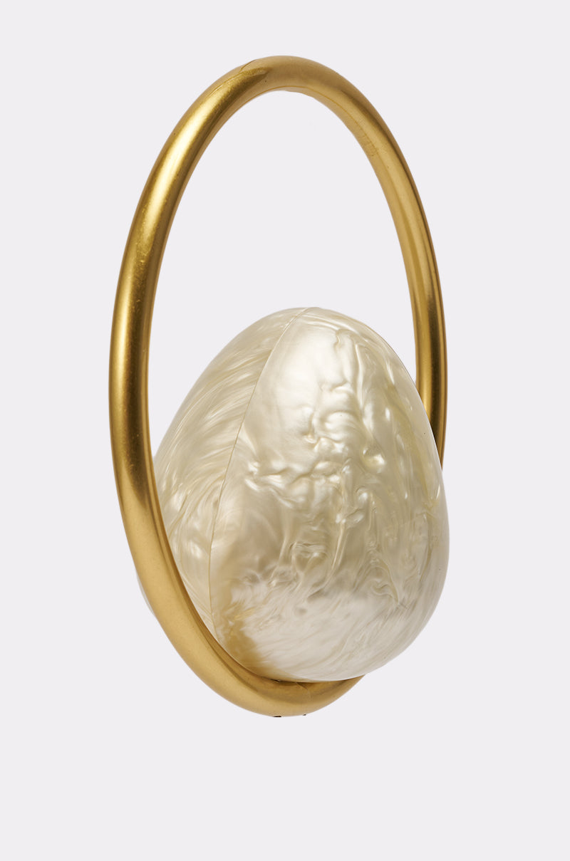 The ON MY MIND BAG is a large, irregularly-shaped, pearlescent accessory with a smooth metallic gold-tone handle, shown against a plain white background. 3