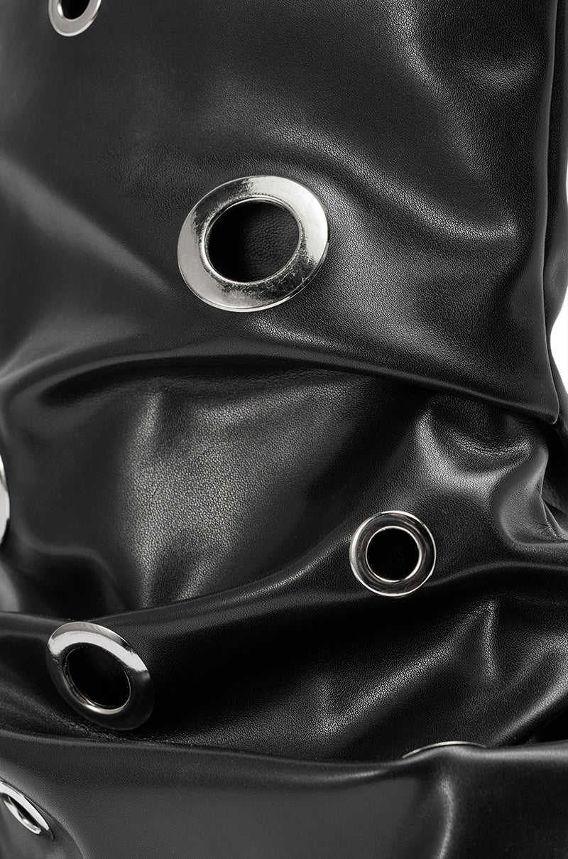 Close-up of glossy black ruched fabric with large silver grommets, reflecting the edgy style of the AKIRA GOLD FABLE BLACK GROMMET EMBELLISHED FLAT BOOTIE for a modern, textured effect.