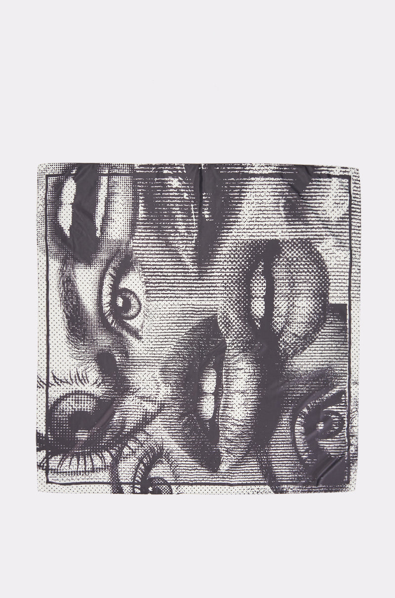 The DISTORTED BEAUTY SCARF is a square satin accessory showcasing a bold graphic print—a black and white collage of illustrated eyes and lips on a white background—perfect for making a statement.