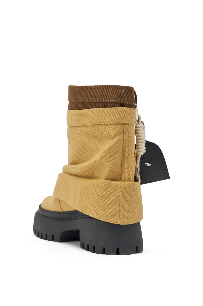 The AKIRA GOLD FAE TAN BOOTIE features a tan and brown slouched canvas upper, platform sole, chunky lug heel, and unique rope detail at the back, shown against a white background. 6