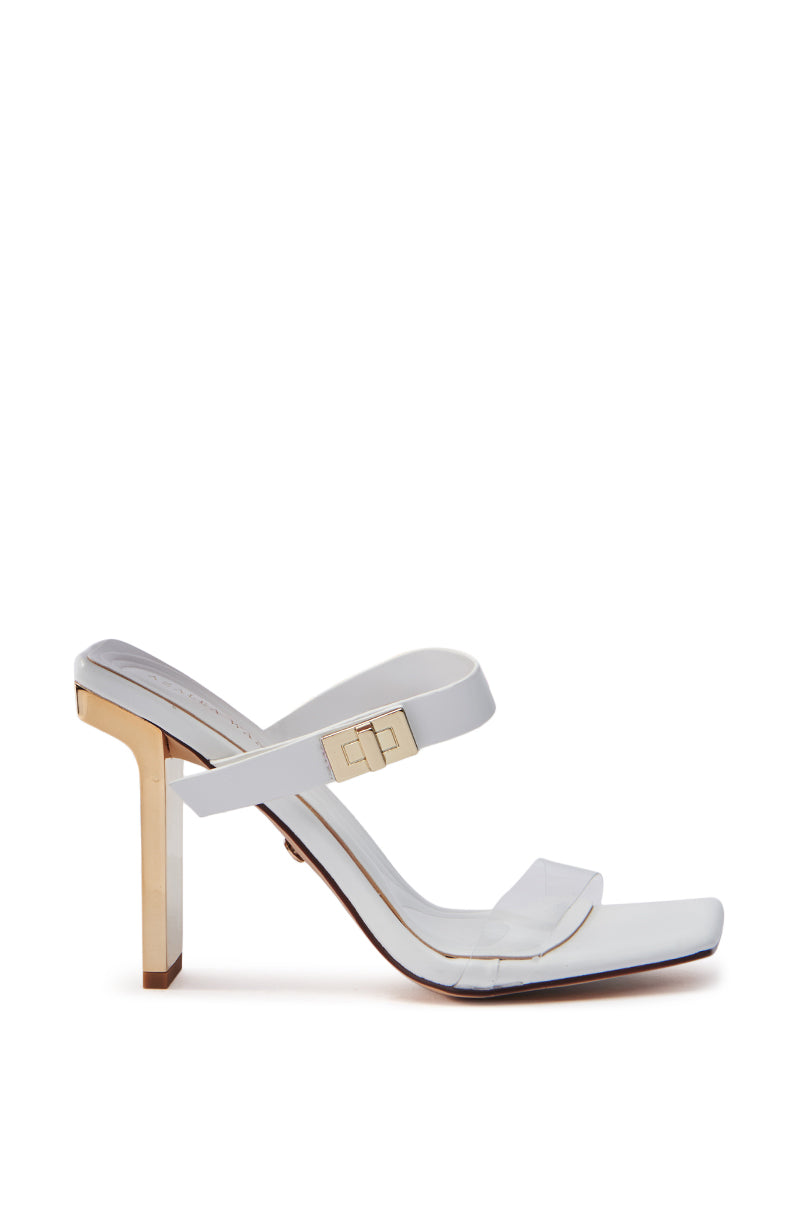 The AZALEA WANG FANAKA WHITE CHUNKY SANDAL is a modern white high-heeled sandal in vegan leather with an open square toe, two clear straps, and a uniquely designed geometric metallic gold heel. It includes a subtle branded accent on one strap for added elegance.