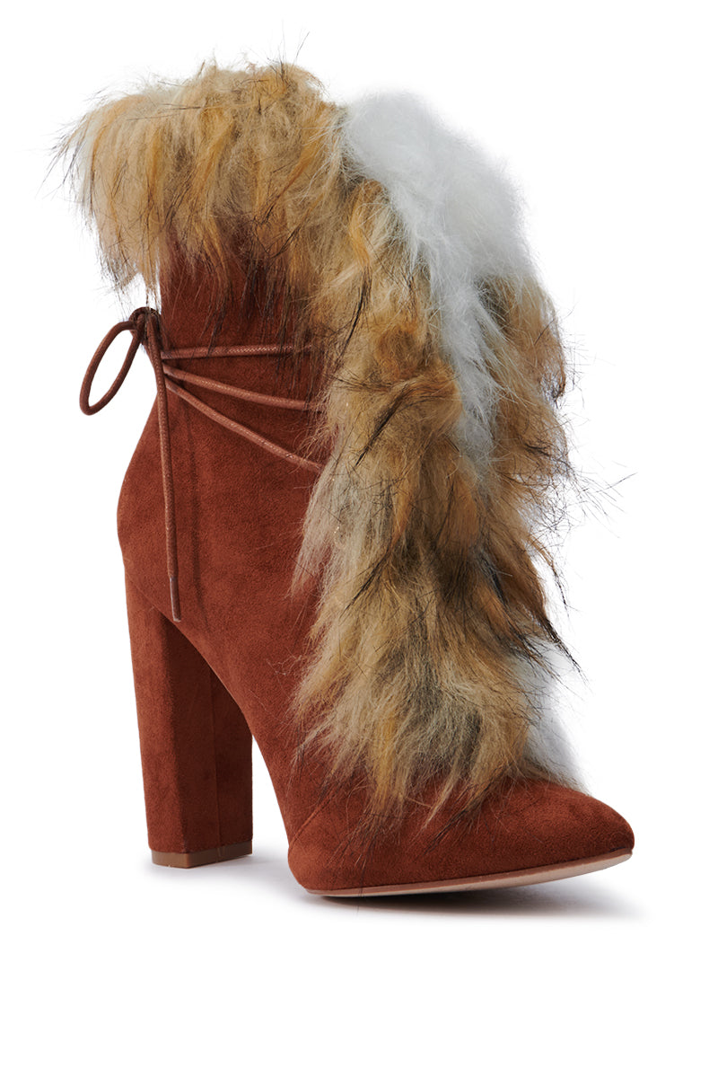 Introducing the FANCY TAN LACE UP CHUNKY BOOTIE WITH FUR: a high-heeled brown faux suede ankle boot featuring a pointed toe and fluffy multicolored fur trim. This stunning design showcases a tied lace detail on the back along with a chunky block heel, making it perfect for adding an elegant touch to any outfit.