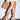 A person in a light yellow dress and AZALEA WANG FANTASA BROWN HALLOW PLATFORM WEDGE STRAPPY SANDALS with ankle ties and chain details, holding a woven straw tote bag, stands against a plain white background.