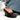 Wearing flared jeans, someone showcases the AZALEA WANG FASCIA BLACK FRINGE WEDGE SANDAL. These vegan leather shoes have a stylish open-toe design, black fringe with silver chain embellishments, and a comfort cushion insole for all-day wear.