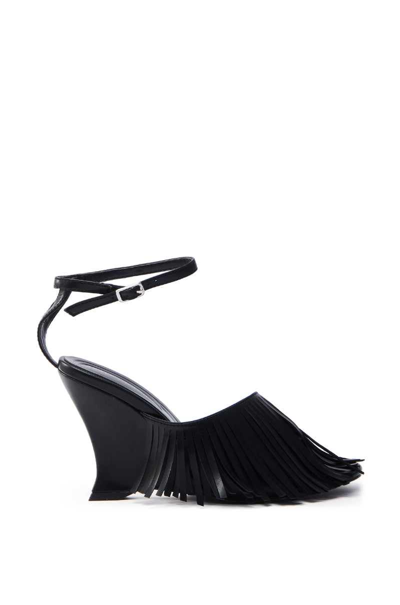 The AZALEA WANG FASCIA BLACK FRINGE WEDGE SANDAL is a stylish vegan leather sandal with an ankle strap and fringe detailing on the front, featuring a smooth, glossy finish and modern silhouette that highlights its fringed embellishments.