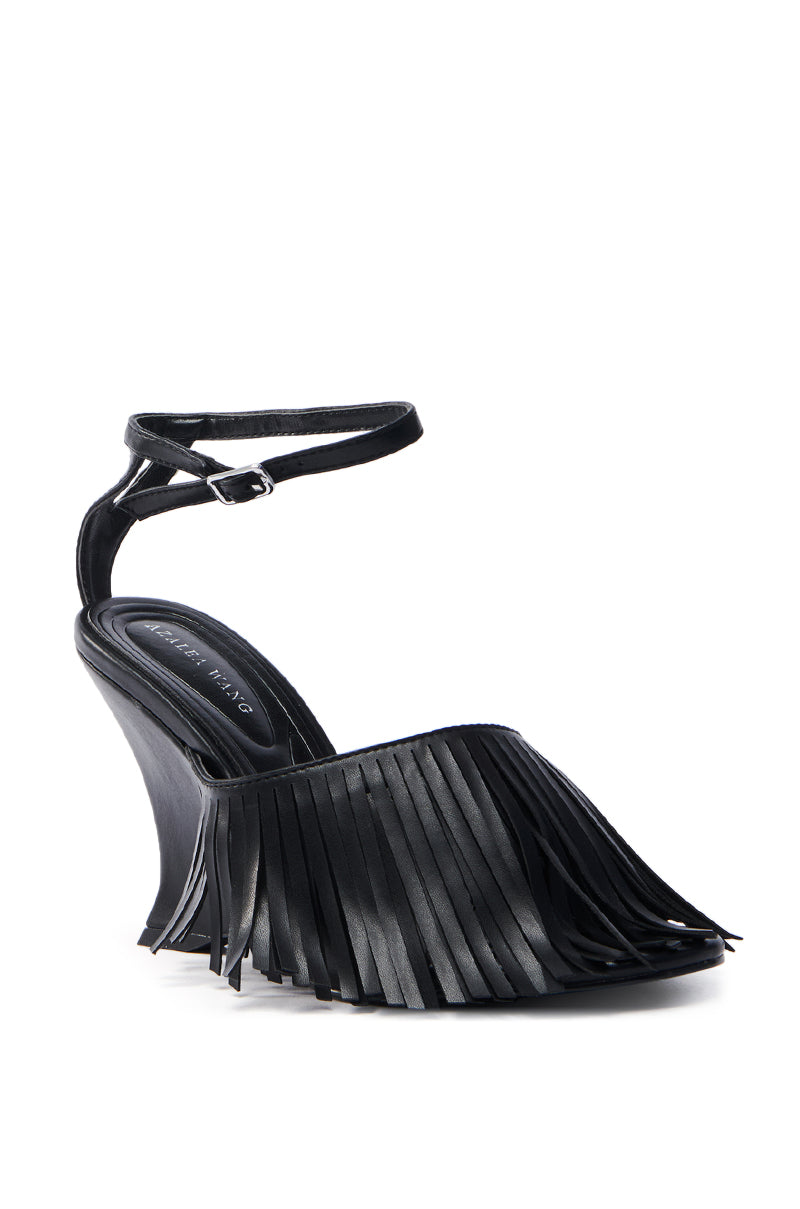 The AZALEA WANG FASCIA BLACK FRINGE WEDGE SANDAL is a vegan leather, black high-heeled wedge with a closed toe and fringe details. It includes an ankle strap with a buckle for a stylish, contemporary look.