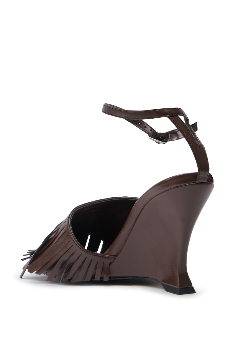 The AZALEA WANG FASCIA CHOCOLATE WEDGE FRINGE SANDAL features faux leather, a back-angled ankle strap, fringe front detailing, and an angular sculptural heel.