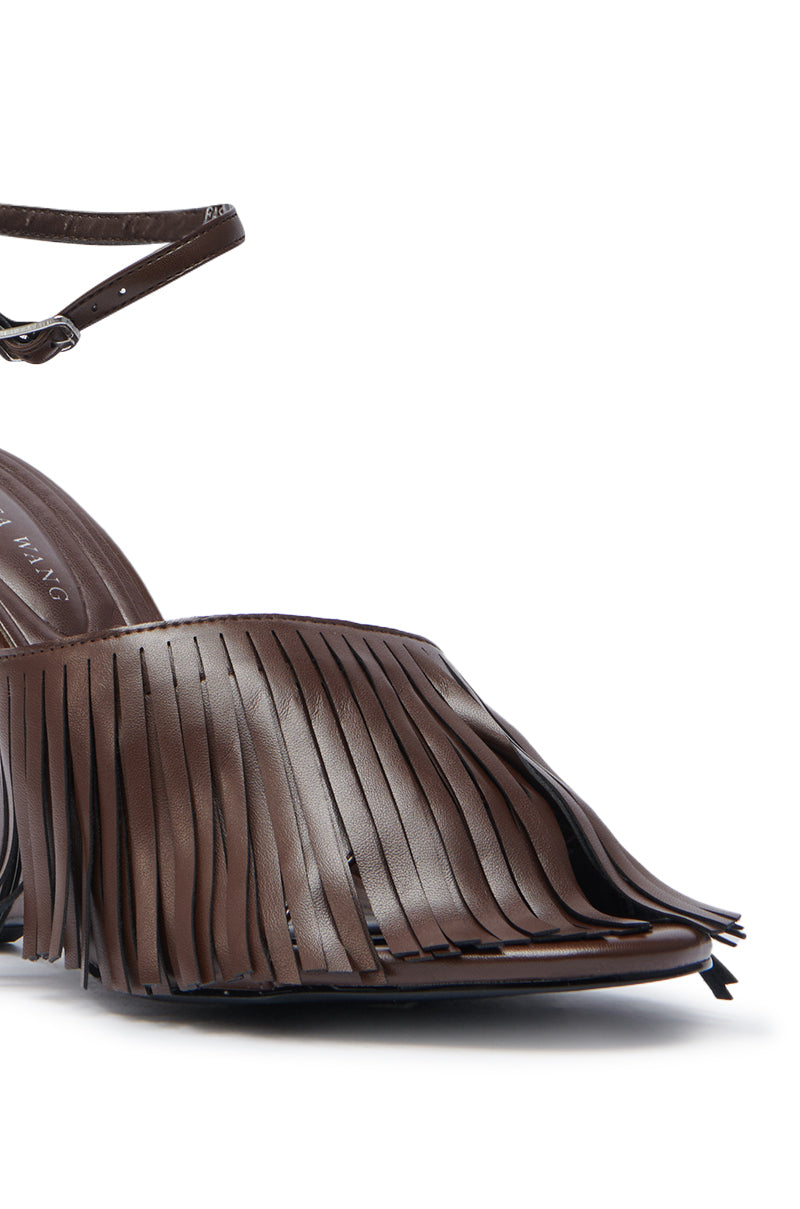 Close-up of the AZALEA WANG FASCIA CHOCOLATE WEDGE FRINGE SANDAL—a brown faux leather shoe with a pointed toe, smooth finish, fringe detailing, and a slim ankle strap.