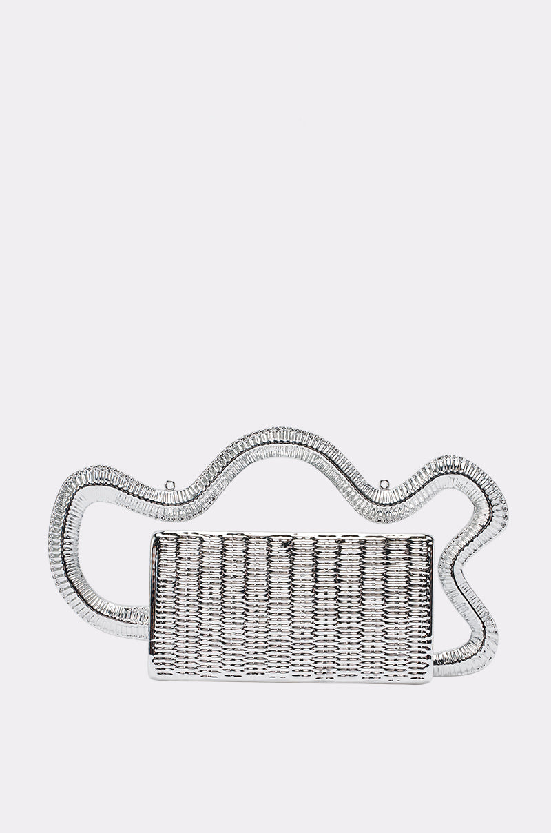 The FREE THINKER BAG is a rectangular, silver metallic clutch with a woven texture and a wavy, sculptural handle on top, set against a plain white background—making it the perfect choice for an elegant evening or wedding clutch.