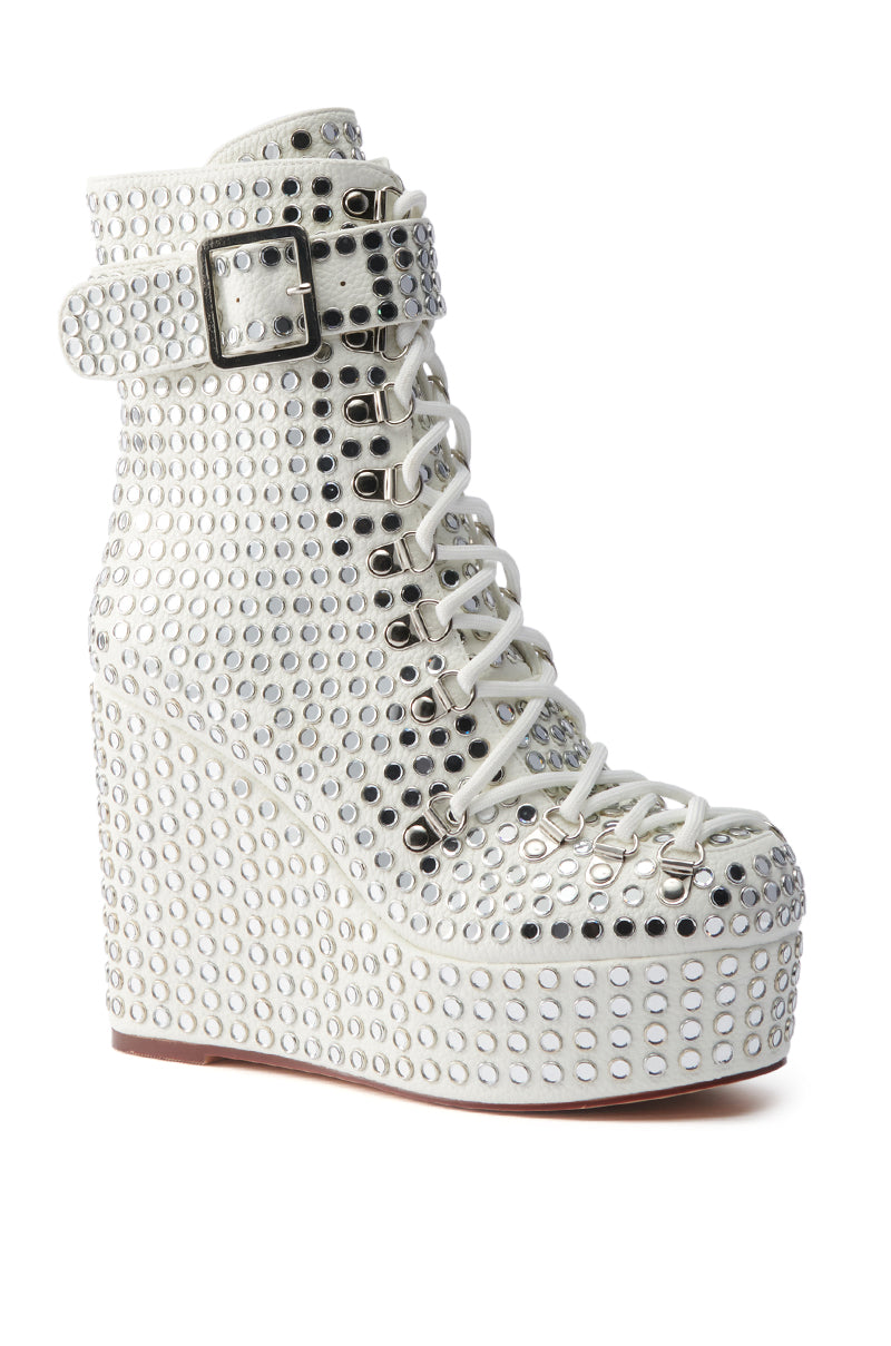 The AZALEA WANG FERDY WHITE PLATFORM EMBELLISHED BOOTIE features a rhinestone-studded upper, lace-up front, ankle strap with buckle, and a chunky white wedge platform sole.