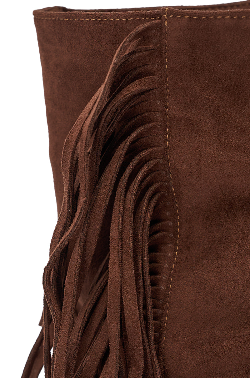 Close-up of brown faux suede with decorative fringe and visible stitching on the AZALEA WANG FIDDA CHOCOLATE GLADIATOR FLAT SANDAL. 6