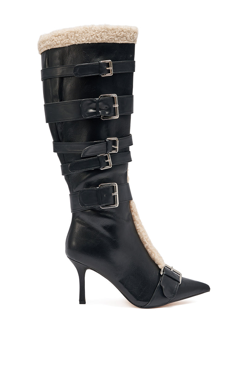 The AKIRA GOLD FIERO BLACK PU AND SHERPA BUCKLE is a black faux leather boot with a pointed toe, stiletto heel, five buckled straps, and beige sherpa trim along the top and inside edge.