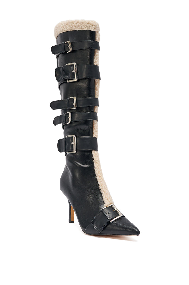 The AKIRA GOLD FIERO BLACK PU AND SHERPA BUCKLE is a black faux leather knee-high boot with five silver buckles, pointed toe, stiletto heel, and cream sherpa trim along the front and top edge.