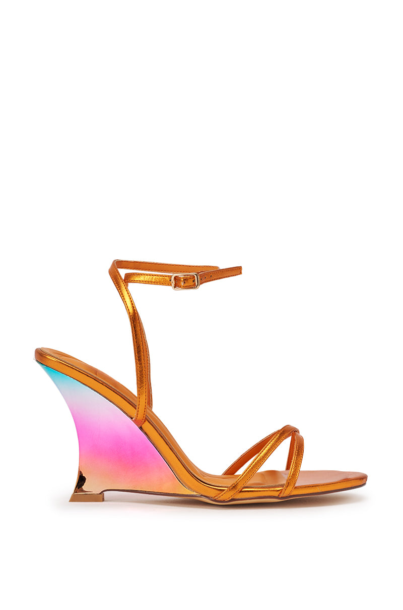 The AKIRA GOLD FINGA CHROME WEDGE STRAP SANDAL is a metallic orange wedge sandal with a slender ankle strap, open toe, and a rainbow ombre heel fading pink to purple to blue—an eye-catching addition to your summer party look. 4