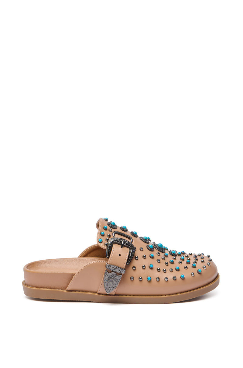 The AZALEA WANG FLAIR TAN EMBELLISHED CLOG is a tan slip-on sandal made of faux leather with a flat sole, featuring small metallic studs, blue embellishments on the upper, and a decorative side buckle.