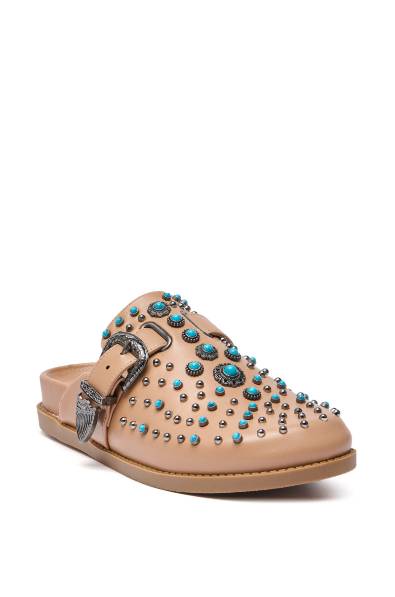 The AZALEA WANG FLAIR TAN EMBELLISHED CLOG is a tan faux leather western-style mule sandal with silver and turquoise studs, a side buckle featuring a Western-style metal accent, shown against a white background.