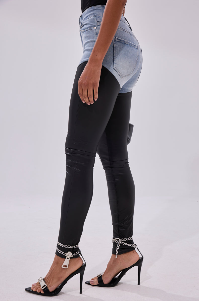 Someone stands against a plain light background, wearing FLEX FIT EXTREME STRETCH HIGH WAIST SKINNY JEANS WITH FAUX LEATHER paired with black high-heeled sandals featuring chain ankle straps.