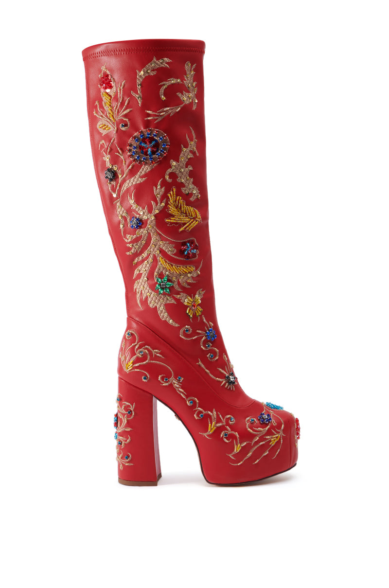 The AZALEA WANG FLIPPER RED PU WITH EMBELLISHMENTS CHUNKY BOOT is a tall, knee-high faux leather boot with a high chunky heel and platform, adorned with intricate gold embroidery and colorful beaded embellishments featuring floral and vine patterns, viewed from the side against a white background.