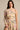 A woman models the JOAN BLOUSE, a cream floral one-shoulder blouse with pink and blue flowers, long sleeve, cropped hem, and a matching high-waisted skirt featuring a thigh-high slit.