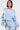 A woman poses confidently against a plain light background, styled in the FLORAL LIFE OFF THE SHOULDER BLOUSE with voluminous ruched sleeves and high-waisted pants.