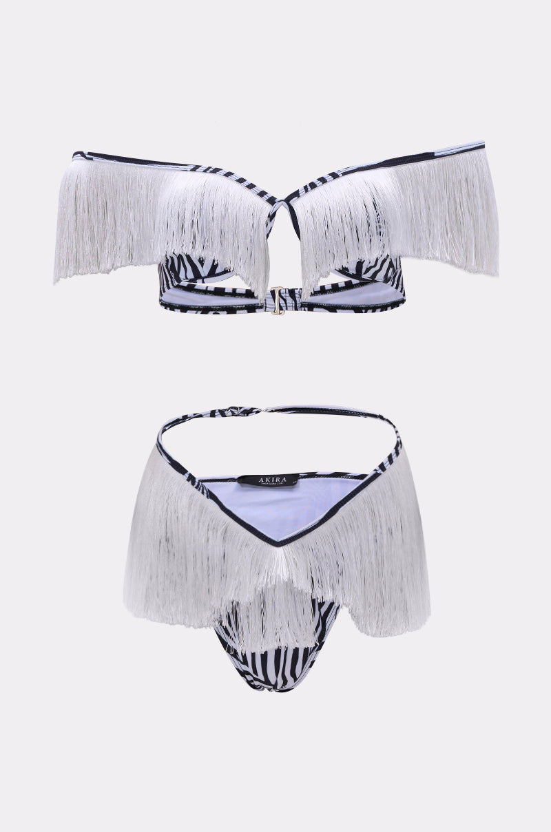 The TOO WILD FOR YOU BIKINI is a two-piece zebra print set with white fringe trim, featuring an off-shoulder top and high-cut bottom, shown against a plain light background.