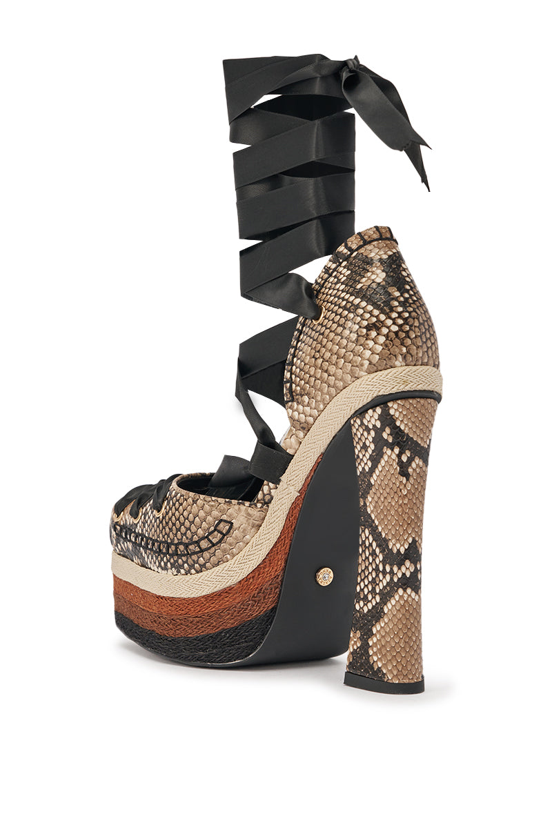 The AZALEA WANG FONTEYN SNAKE PLATFORM PUMP is a faux leather platform with a brown and black snakeskin pattern, chunky block heel, layered sole, and black ribbon ankle straps. 6