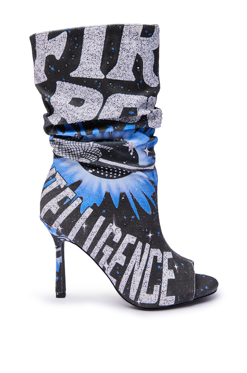 The AKIRA GOLD FORMIDABLE BLACK MULTI ABSTRACT OPEN TOE BOOTIE is a high-heeled, open-toe bootie with a slouchy shaft, stiletto heel, and bold black, blue, and white abstract graphic print featuring large text and starburst patterns.