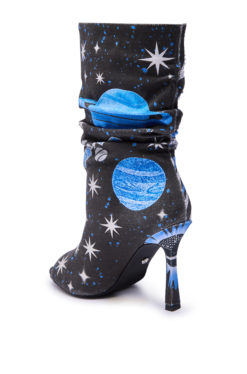 The AKIRA Gold Formidable Black Multi Abstract Open Toe Bootie features a high stiletto heel and slouchy shaft, showcasing a cosmic blue planet and white star print on black for an out-of-this-world style.