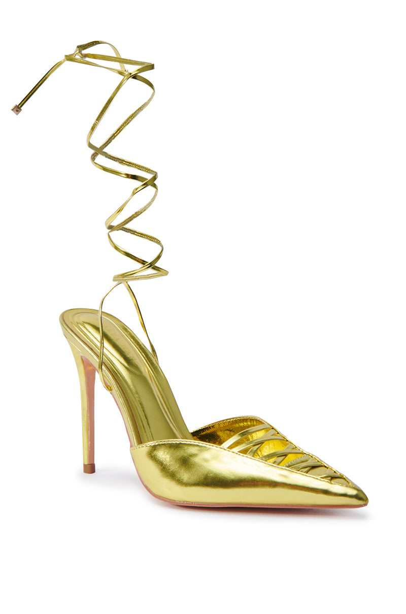 The AZALEA WANG FRIDLI YELLOW LACE UP PUMP showcases a single gold stiletto heel with a glossy finish, featuring a pointed toe and intricate lace-up straps extending upwards, offering a sophisticated and elegant design.