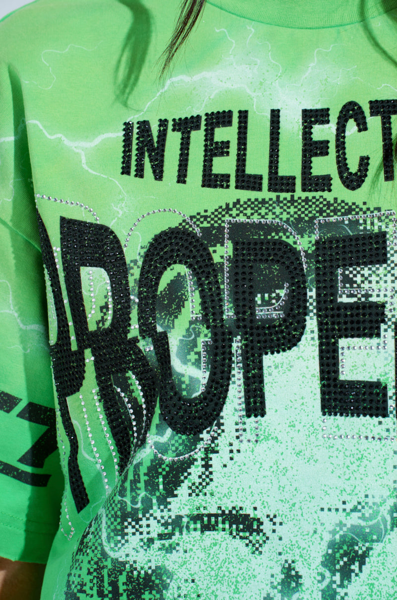 Wearing the vibrant green INTELLECTUAL PROPERTY GRAPHIC TEE, featuring "INTELLECT" and "PROPE," this oversized shirt combines darker digital patterns with striking graphics for a futuristic touch.