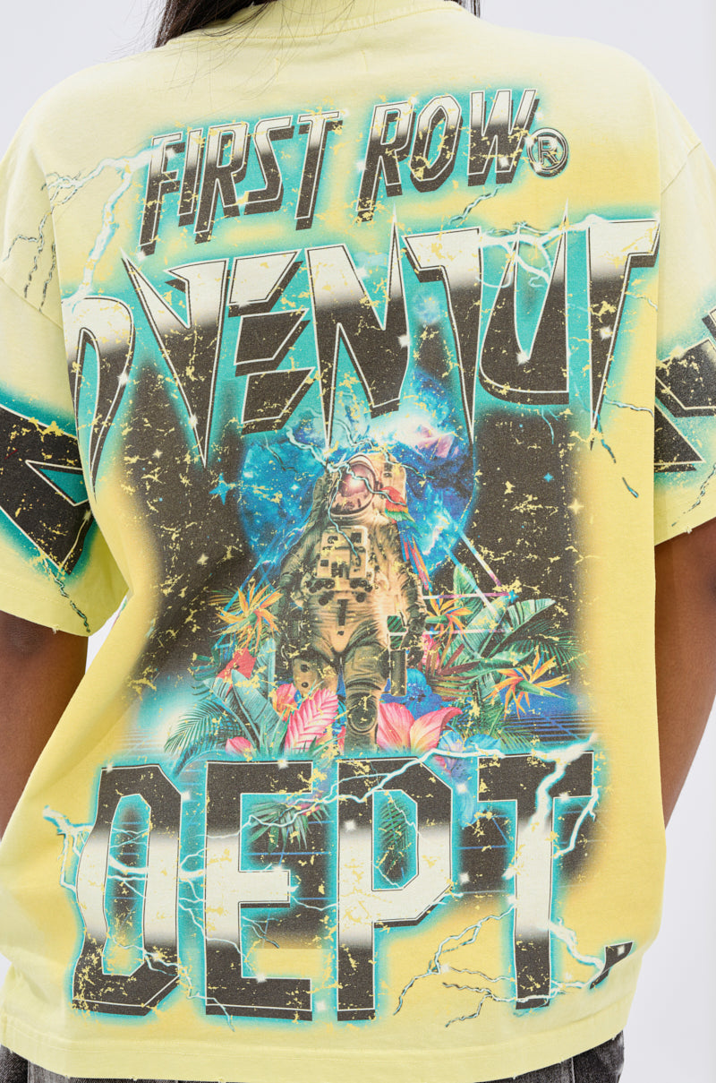 Wearing the EARTH FIRST OVERSIZED GRAPHIC TEE in yellow, with cracked "FIRST ROW ADVENTURE DEPT" text and a bold astronaut among tropical plants on blue—ideal for eco-conscious fashion enthusiasts.