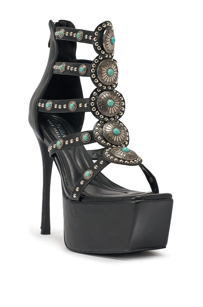 The AKIRA GOLD FUANMARA Black Embellished Sexy Stiletto PU Sandal features black faux leather, a stiletto heel, and multiple straps with silver conchos and turquoise stones for a bold boho-chic style. 4