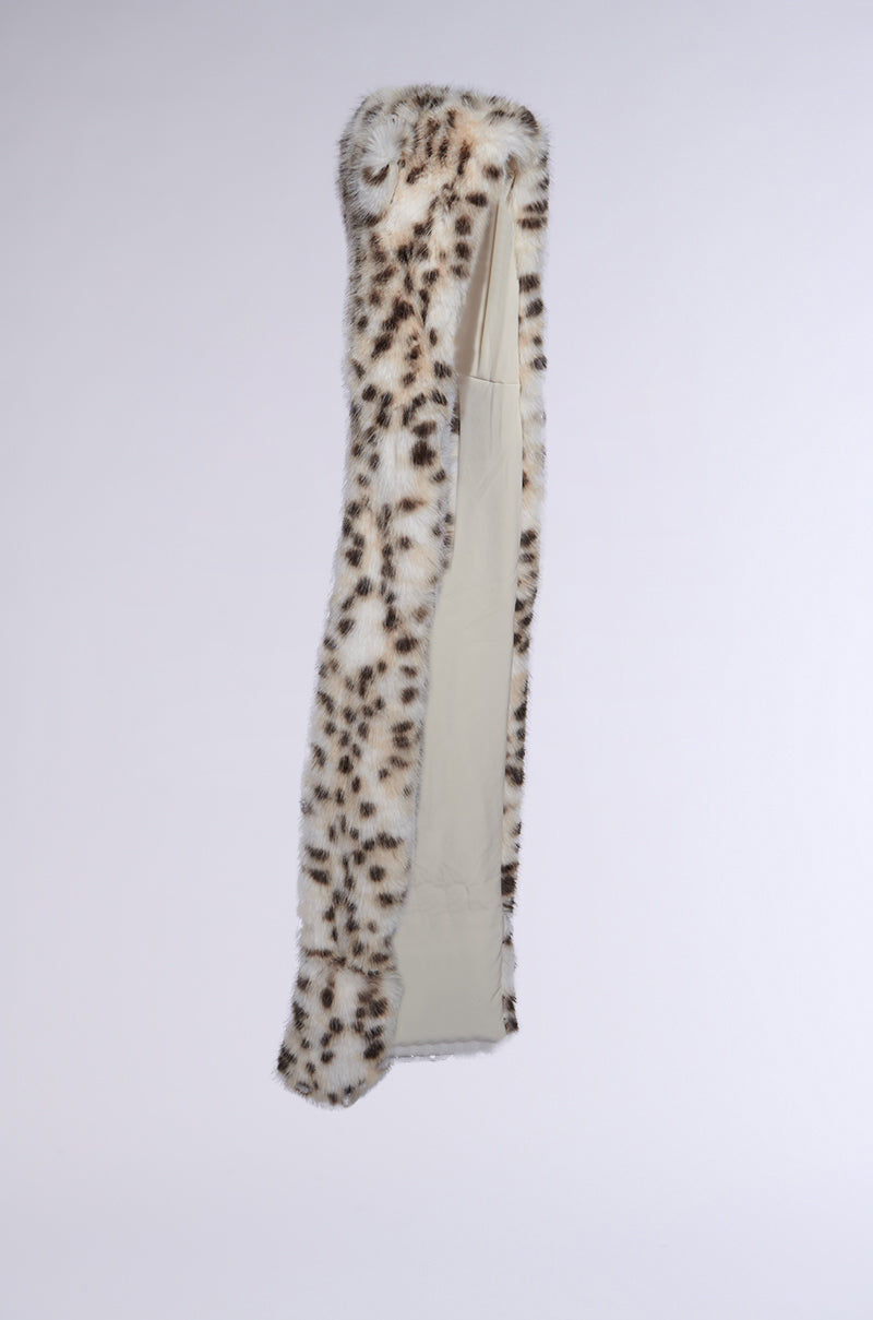 An ANIME DREAMIN FAUX FUR HOOD, featuring a long snow leopard print design, hangs elegantly on a hanger against a plain white background. The playful spotted exterior is contrasted by a beige lining, adding a subtly kawaii charm. 6
