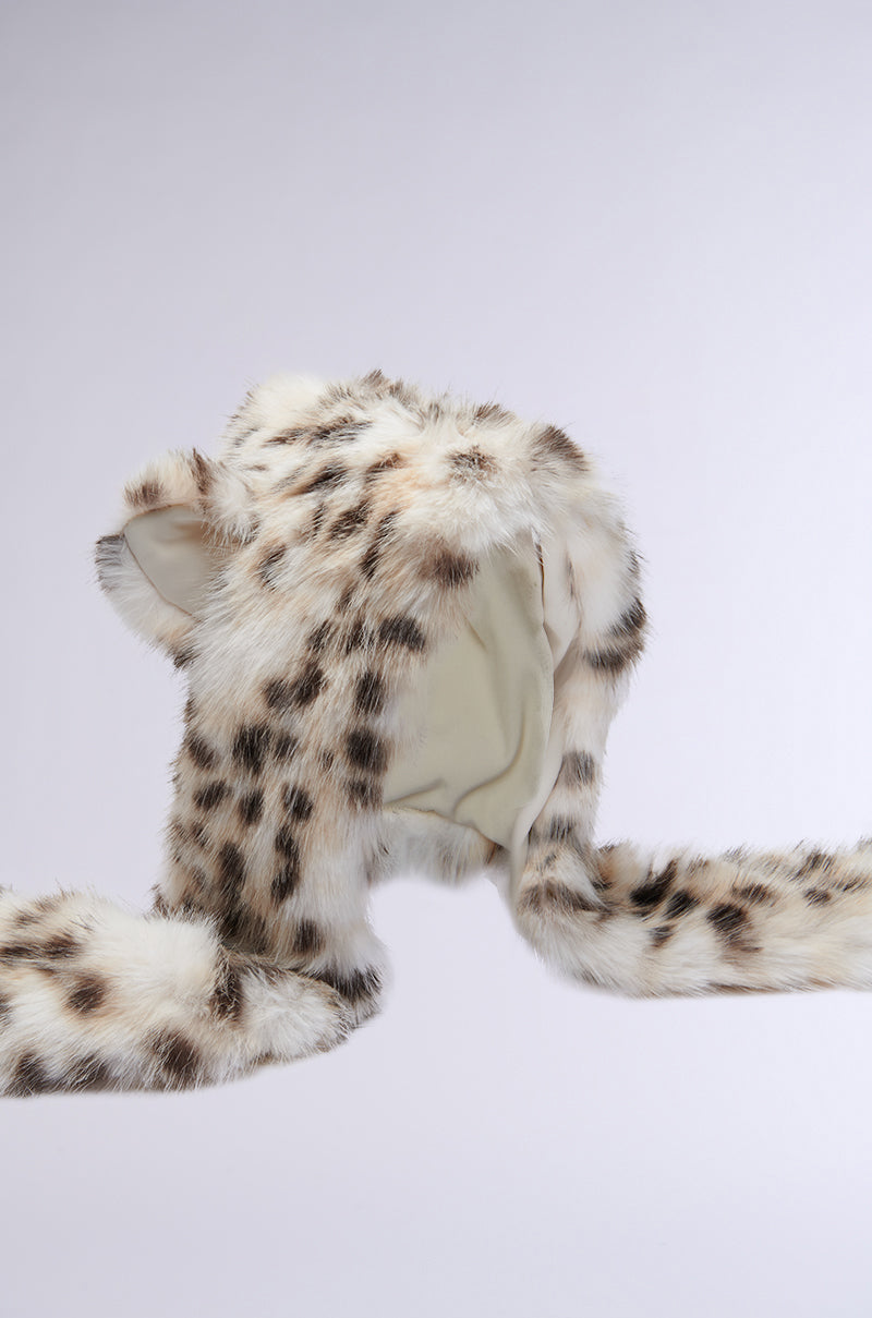 The ANIME DREAMIN FAUX FUR HOOD is a kawaii fur accessory with a snow leopard print, showcasing small ears on top and long, scarf-like extensions. This adorable faux fur hood is elegantly presented against a light gray background. 8