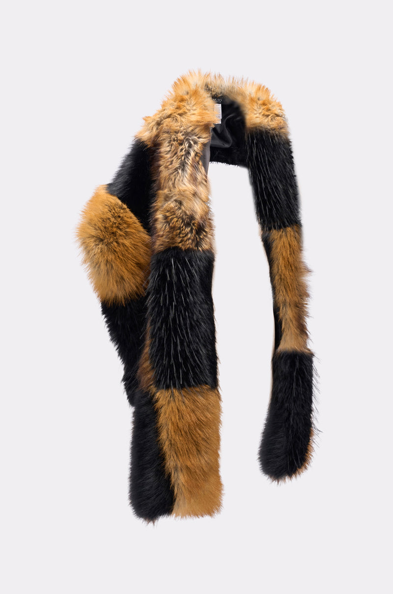 The COSMO FAUX FUR SCARF, featuring an oversized patchwork design in orange-brown, black, and cream, is draped in a curved shape against a plain light gray background. 4
