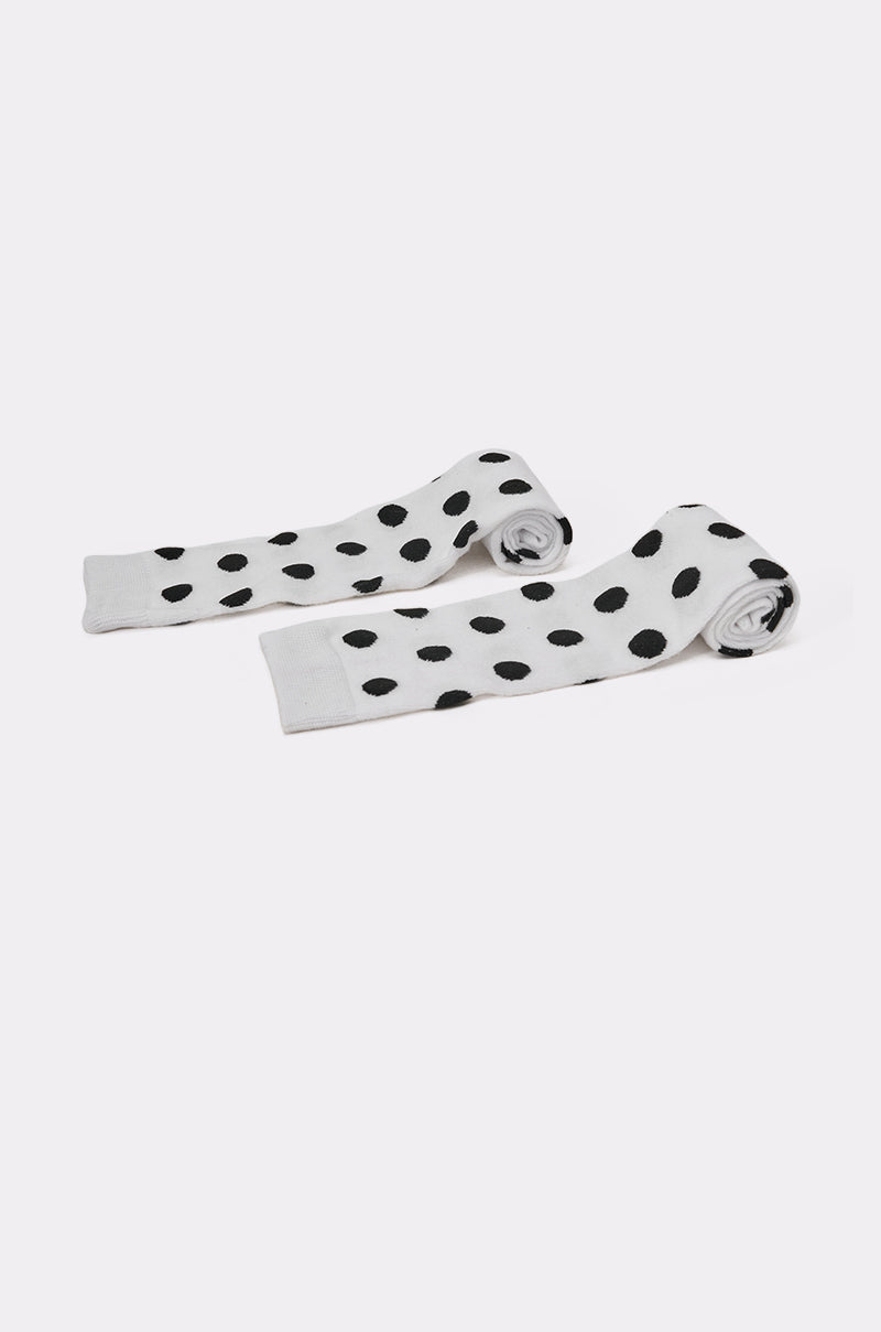 The CALL ME DOTTIE KNEE HIGH SOCKS, featuring white polka dots, are neatly rolled at one end and displayed side by side on a plain white background. 3