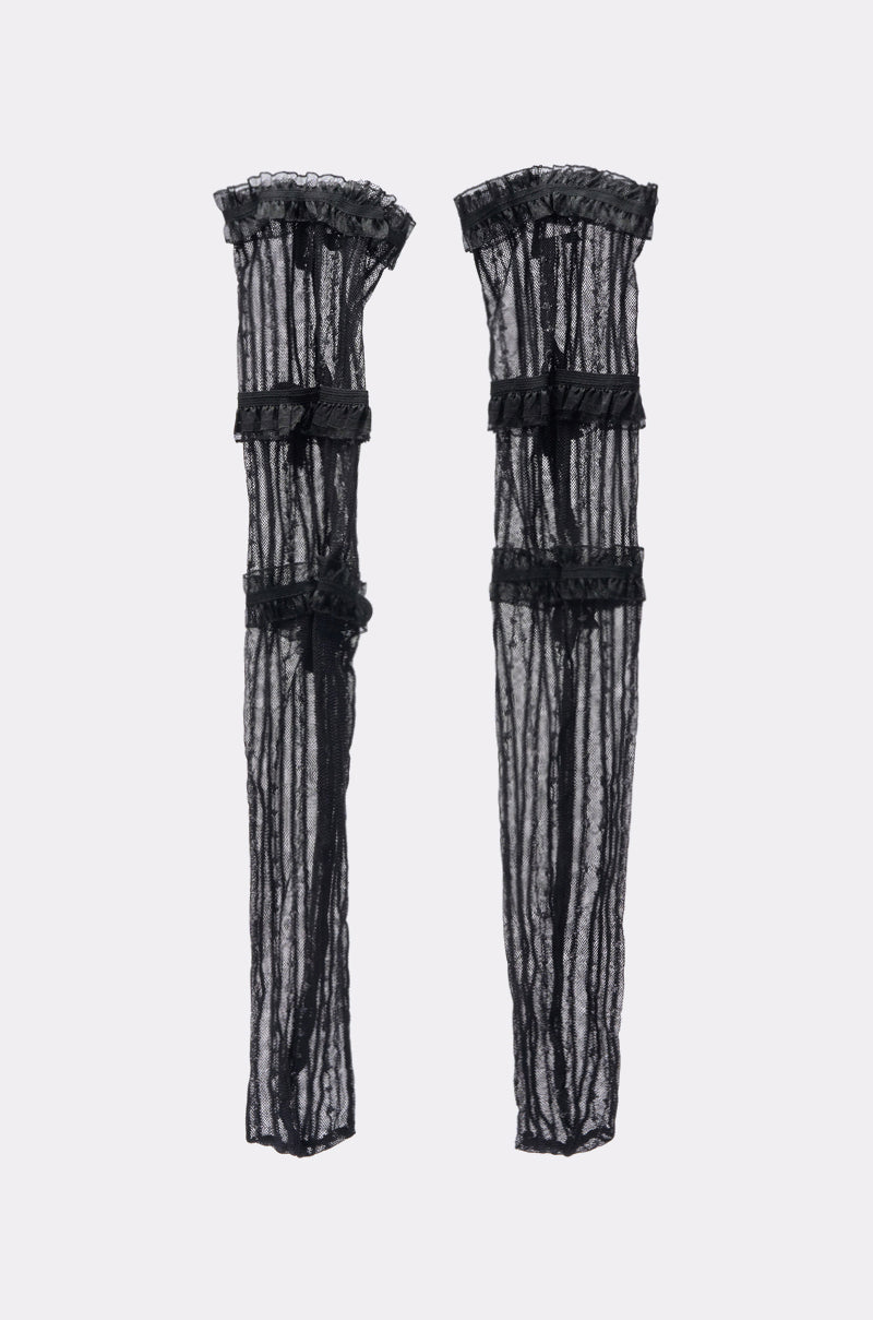 PRETTY N PROPER BOW SOCKS: Long, sheer black lace arm warmers with ruffled edges and horizontal ribbon accents evoke the delicate style of mesh socks, shown flat on a light gray background. 2